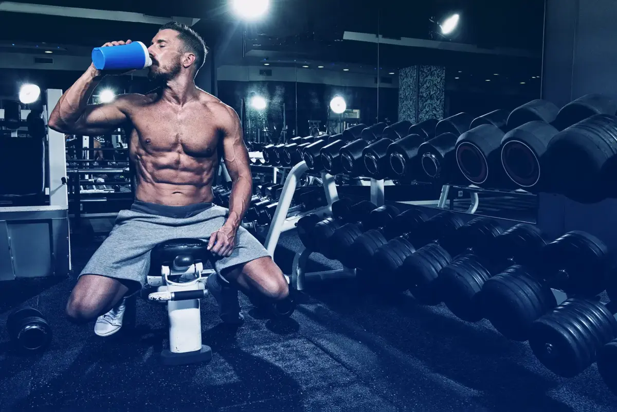 man drinking protein at gym