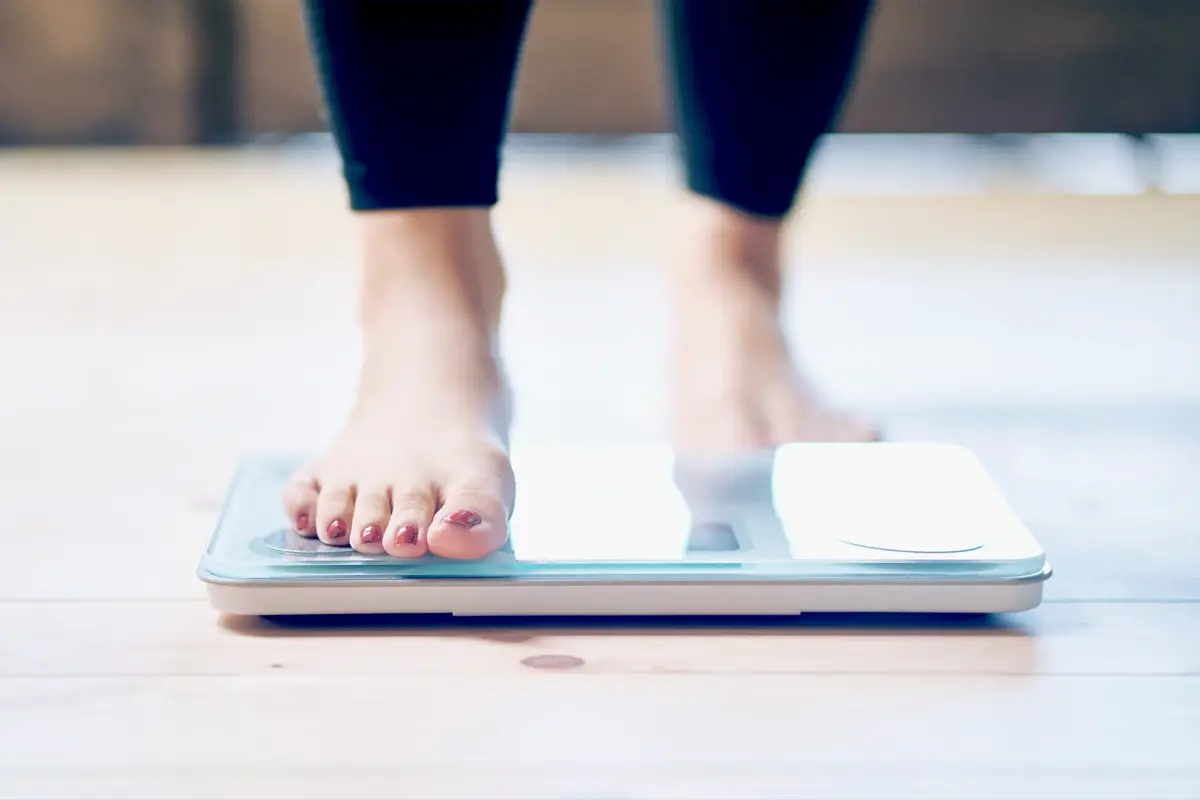 woman stepping onto a scale