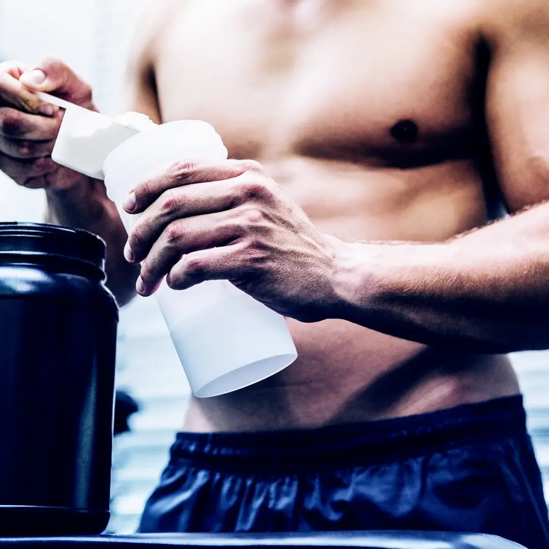 man adding creatine to bottle