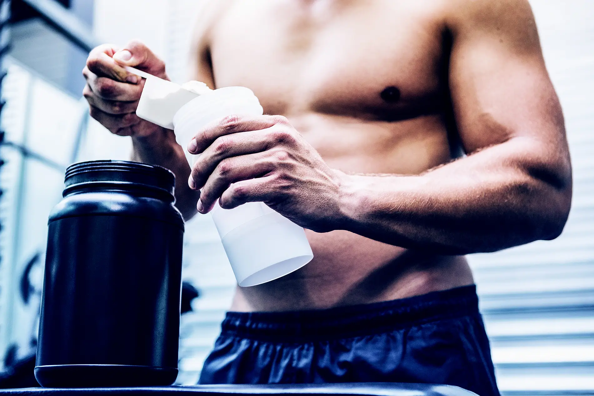 man adding creatine to bottle