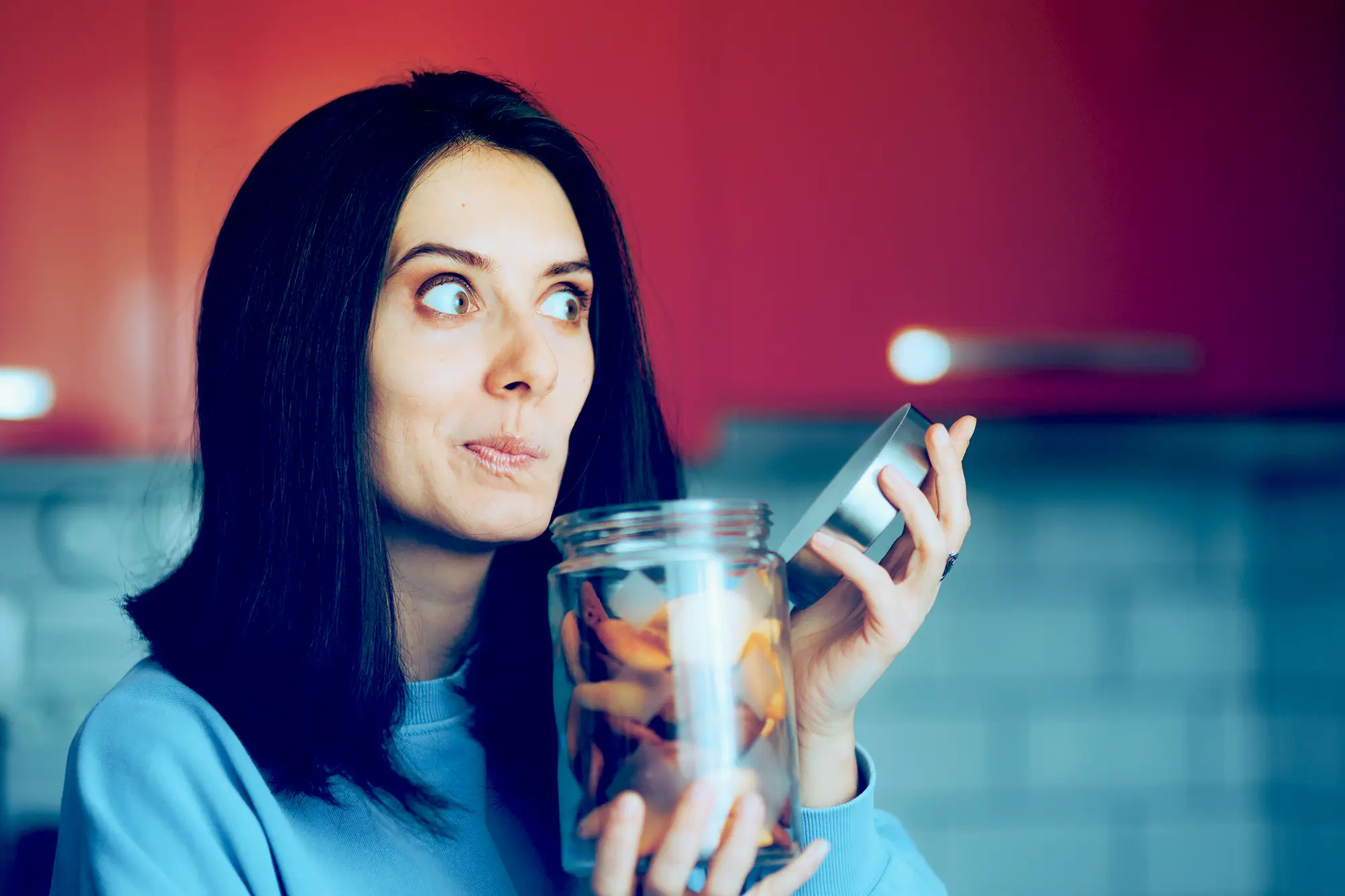 woman with jar making a face